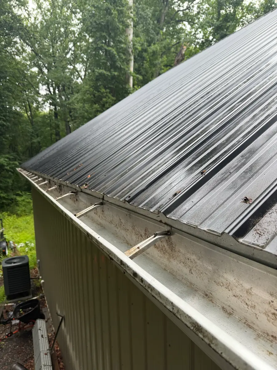 A gutter cleared of leaves, seen from the ladder